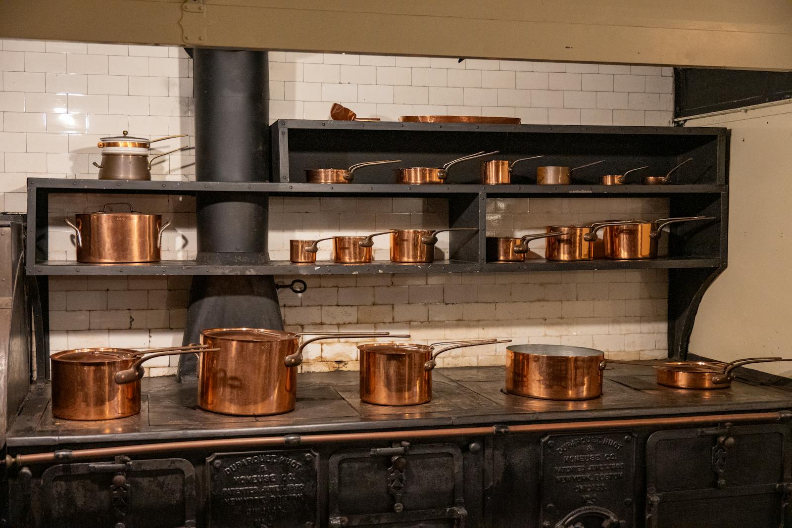 Batterie de cuisine en cuivre ancien sur fourneau patiné