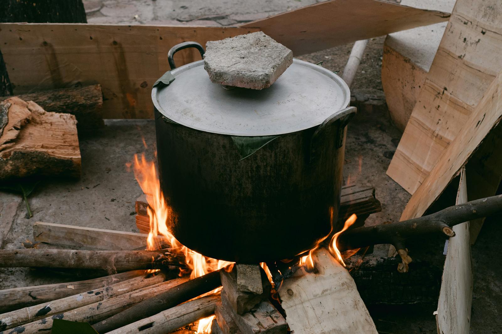 Grande marmite en fonte noire sur grand feu de bois, cuisson lente du bouillon de bouillabaisse — Les Tamaris, Saint-Clair Le Lavandou
